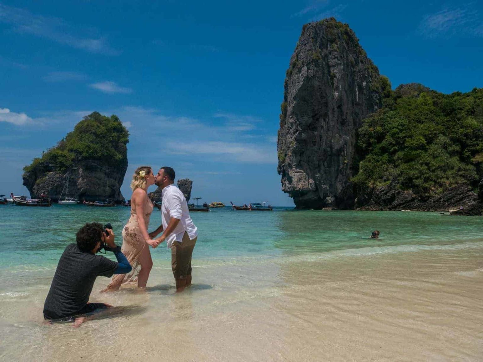 Um fotógrafo tirando foto de um casal em uma praia da Tailândia