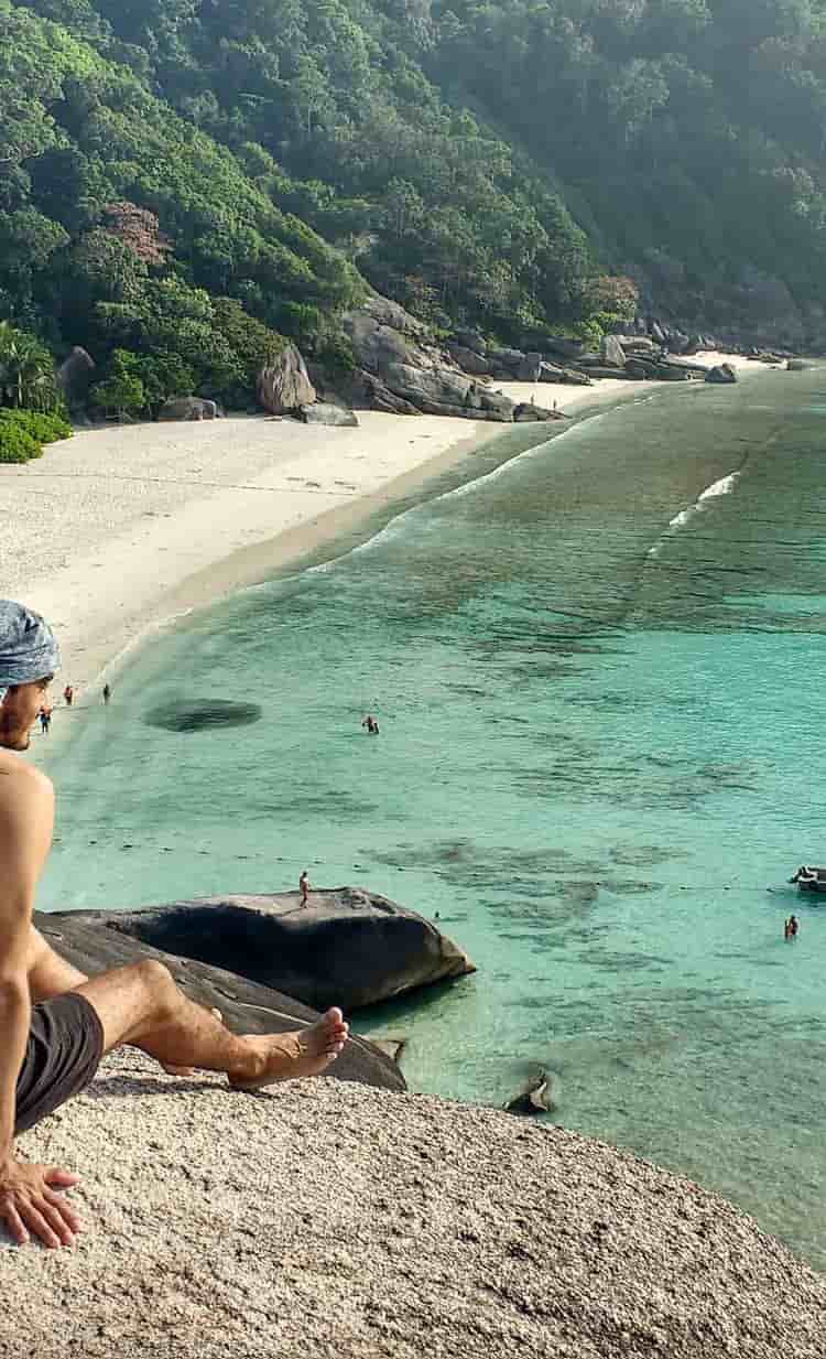 um homem sentado em uma pedra no view point da praia de Similan Island