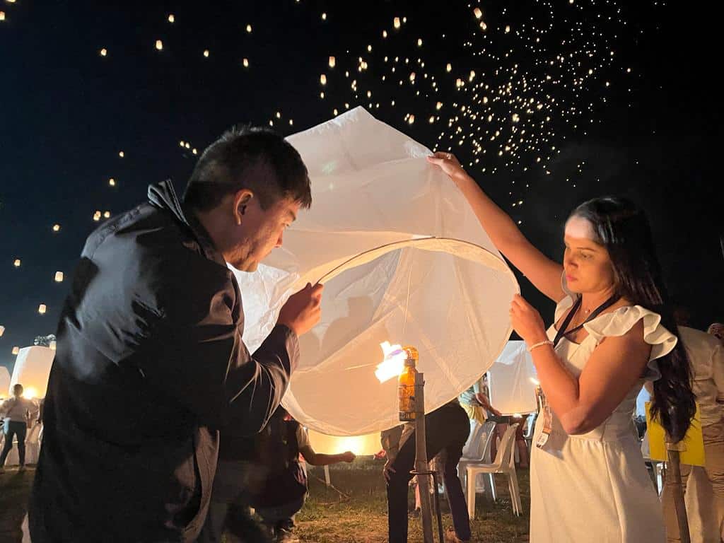 Casal acendendo lanterna no Festival das Lanternas