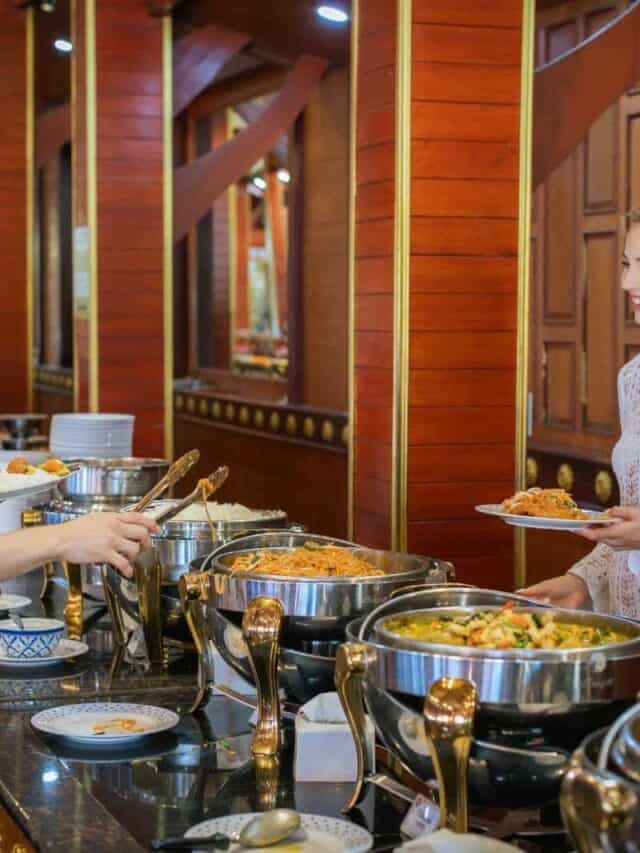 Phi Phi Brazuca, buffet de comida com casal sorridente em restaurante tropical.