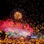 Foguetes e lanternas iluminam o céu durante celebração na Tailândia.