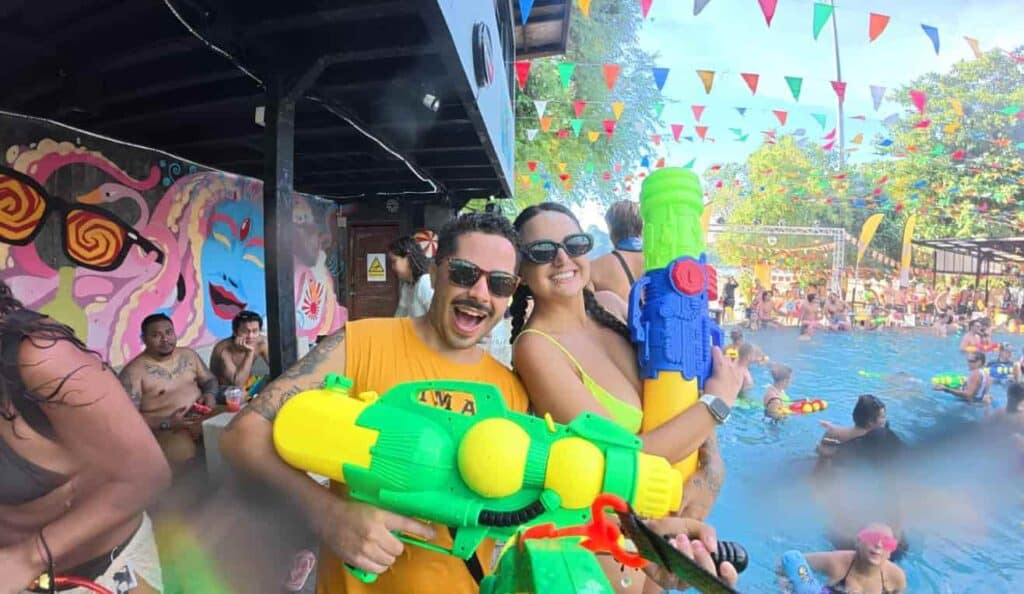 Imagem de pessoas se divertindo com pistolas d'água em parque aquático na Tailândia.