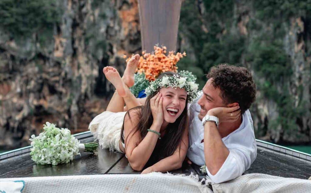 Casal sorridente na praia de Phi Phi Brazuca, curtindo o mar e a natureza.